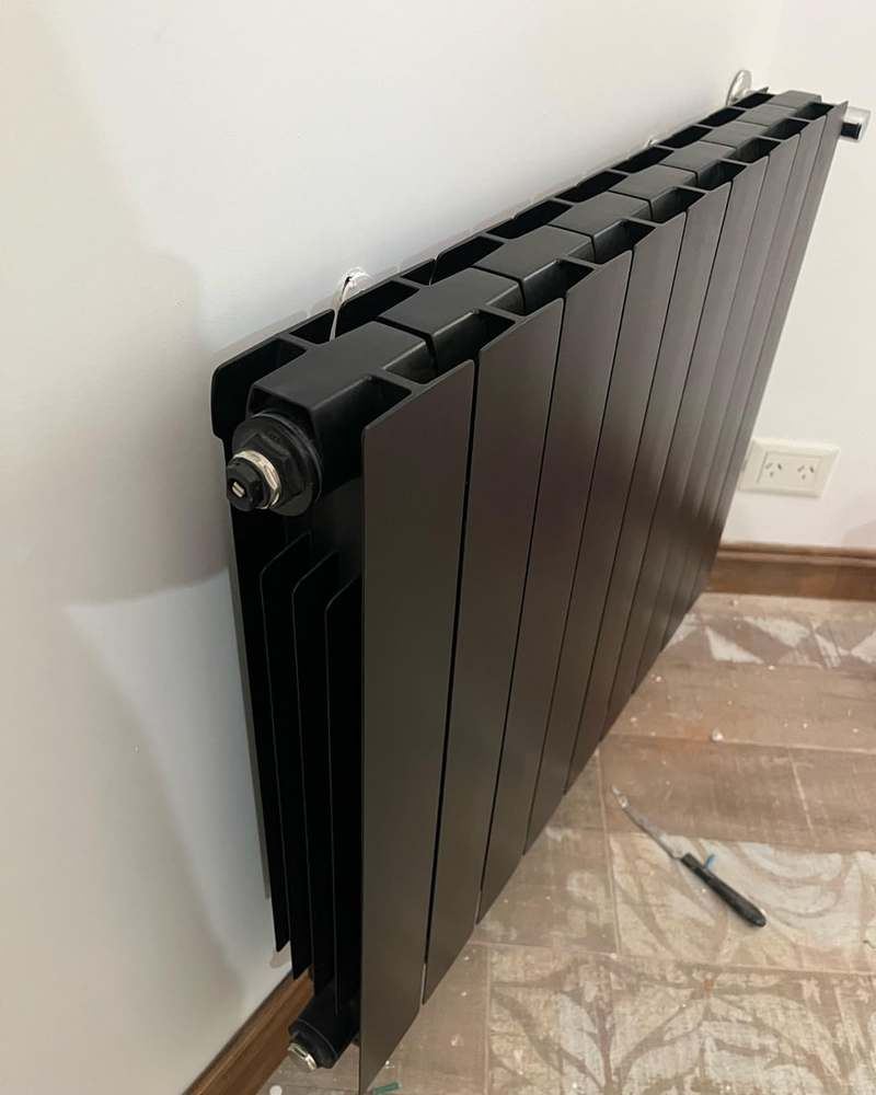 Radiador negro moderno, detalle de válvula